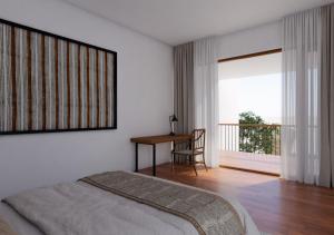 a bedroom with a bed and a desk and a window at vrihee resort in Weligama