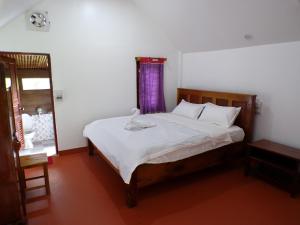 a bedroom with a large bed with a purple curtain at Namnoncave Resort 
