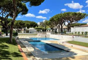 a swimming pool in a park with trees at BnB Homes Coastal Pearl Apartment with 2 Pools near to Falesia Beach in Albufeira