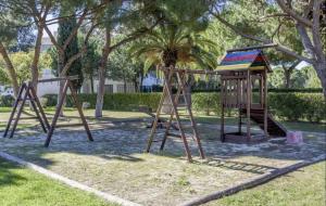 a playground with two swings in a park at BnB Homes Coastal Pearl Apartment with 2 Pools near to Falesia Beach in Albufeira