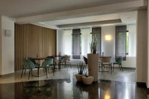 a dining room with tables and chairs and windows at Waldhotel Wandlitz in Wandlitz
