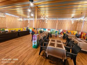 a restaurant with tables and chairs in a room at Hotel Chandan Heritage in Bhubaneshwar