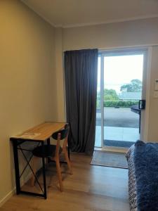 OmokoroaにあるLakaz Beach houseのテーブルとソファ、窓が備わる客室です。