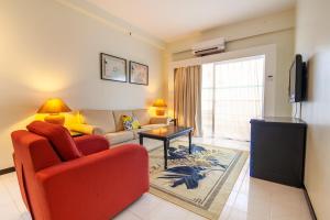 a living room with a red couch and a tv at Rainbow Paradise with Beach in Tanjung Bungah in Tanjung Bungah