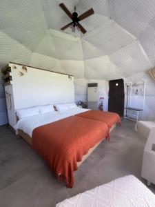 een slaapkamer met een groot bed met een plafond bij glamping base YOLO in Nakijin +23 foto's