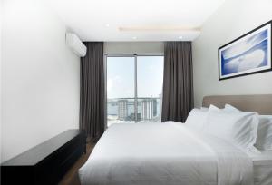 a bedroom with a white bed and a large window at CASA by Meridian in Phnom Penh