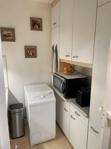 a small kitchen with a stove and a microwave at Skipper am Steinhuder Meer in Steinhude +6 photos