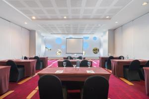 a conference room with tables and chairs and a screen at Ibis Styles Malang in Malang +32 photos