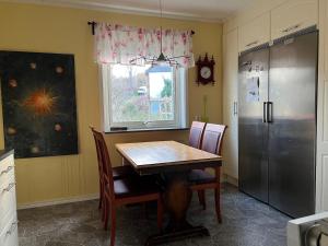 a kitchen with a table and a refrigerator at Jägaregatan 10 in Tranås