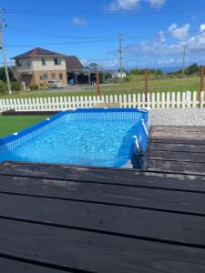 a blue swimming pool next to a white fence at glamping base YOLO in Nakijin