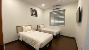 Una habitación de hotel con dos camas y una ventana. en Yên Tử Boutique Hotel, en Yên Dương 9 fotos más