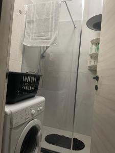 a small bathroom with a washing machine and a shower at Casa Maya Langhe e Roero in Pocapaglia