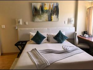 a bedroom with a white bed with blue pillows at Not Today Guest Lodge in Mthatha