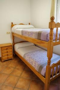 two bunk beds in a room with a tiled floor at Edelweiss con WIFI y parking in Sierra Nevada