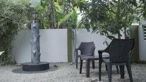 3 sillas y una mesa en un jardín en Avaiaa, en Varkala 13 fotos más