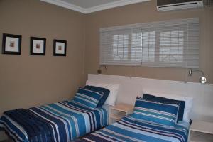 a bedroom with two beds with blue and white pillows at Natspat 20 in Margate