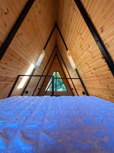 a large room with a large bed in a wooden room at Macko’s cabin in Băile Tuşnad