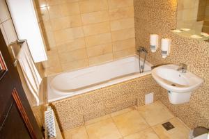 a bathroom with a tub and a toilet and a sink at Amadé Pension in Siculeni +78 photos