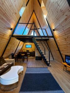 a loft with a staircase and a living room at Macko’s cabin in Băile Tuşnad