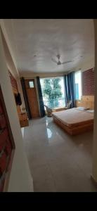 a large bedroom with a bed and a window at White Water Inn Mcleodganj in Dharamshala