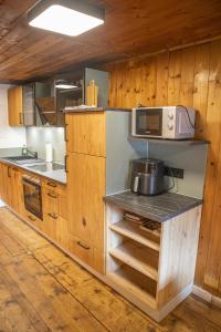 a kitchen with wooden cabinets and a microwave at ZumHubertus in Bschlabs