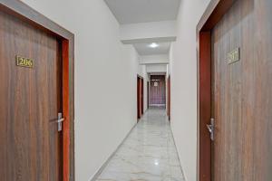 a hallway with two wooden doors and a hallway with a floor at FabHotel Galaxy Greno Celebration in Greater Noida