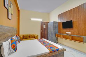 a bedroom with a bed and a tv on the wall at FabHotel Galaxy Greno Celebration in Greater Noida