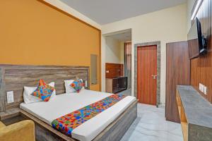 a bedroom with a large bed and a television at FabHotel Galaxy Greno Celebration in Greater Noida