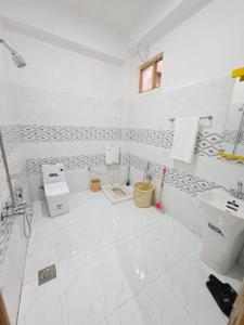 a white bathroom with two toilets and a sink at Beach Resort in Kalām