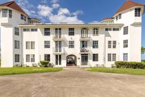 an exterior view of a large white building with a driveway at Seacastles by the beach/pool in Montego Bay