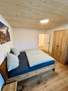 a bedroom with a bed and a wooden ceiling at FeWo 1 Heudorfer in Schlier