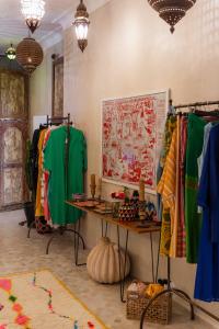 マラケシュにあるRiad La Lumière d'Étoileのテーブルといくつかの衣服が展示されている部屋