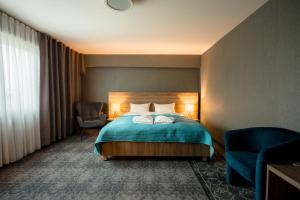 a hotel room with a bed and a chair at Hotel Porto in Radomsko +82 photos