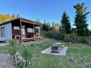 a small cabin with a grill in a yard at The Little House in Knysna
