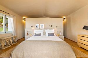 a bedroom with a large bed with white sheets at Discreet Luxury Home With Splendid Views in La Cimada