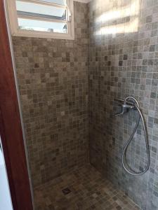 a bathroom with a shower with a glass door at Studio à Tamaon 