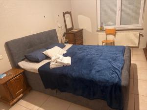 a bedroom with a large bed with a blue blanket at Quarto Duplo in Differdange