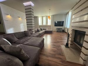 Una sala de estar con un sofá y una chimenea. en Yarema Forest House, en Yarema residence zone