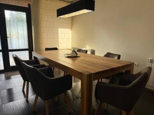 Un comedor con mesa y sillas de madera. en Yarema Forest House, en Yarema residence zone
