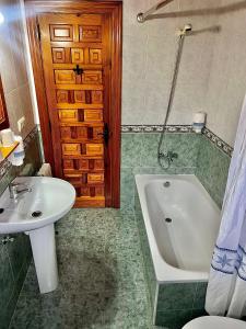 a bathroom with a sink and a tub and a toilet at Hotel Rural El Sestil in Dobres