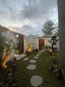 a garden with stepping stones in front of a house at Villa Daisy Private Pool in Tanah Lot