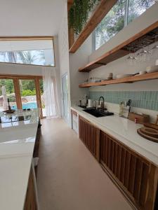 a kitchen with white counters and a large window at Villa Verde Ko Phangan in Haad Pleayleam