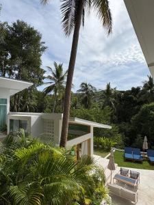 a house with a palm tree and a patio at Villa Verde Ko Phangan in Haad Pleayleam +32 photos