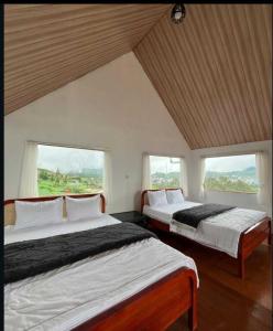two beds in a room with two windows at Umacabana 2 in Dieng +31 photos