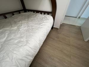 an unmade bed in a room with a wooden floor at Shenzhen Beacon Hostel in Shenzhen