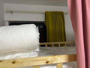 a bed with a wooden frame and a window with avertisement at Shenzhen Beacon Hostel in Shenzhen