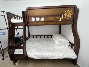 a wooden bunk bed with a white pillow on a shelf at Shenzhen Beacon Hostel in Shenzhen