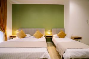two beds in a room with yellow pillows on them at 4 Seasons Roma Trastevere in Rome +65 photos