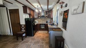 eine Küche mit einem schwarzen Kühlschrank und einer Theke in der Unterkunft Къща за гости Начовата къща, Стойките, община Смолян in Vodata