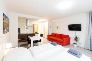 - un salon avec un lit et un canapé rouge dans l'établissement 101 Athen, Studio Apartment, 38m2 1-4 Pers, à Klagenfurt am Wörthersee
